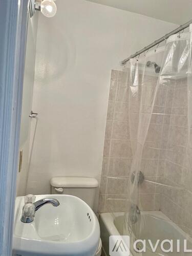 A bathroom with a white sink and a shower curtain.