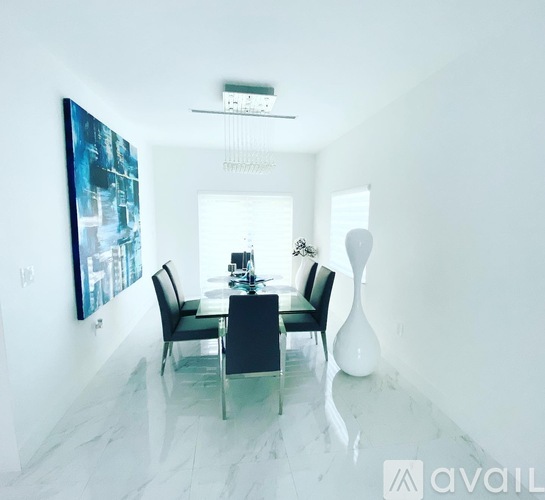 A modern dining room with a glass table and chairs.