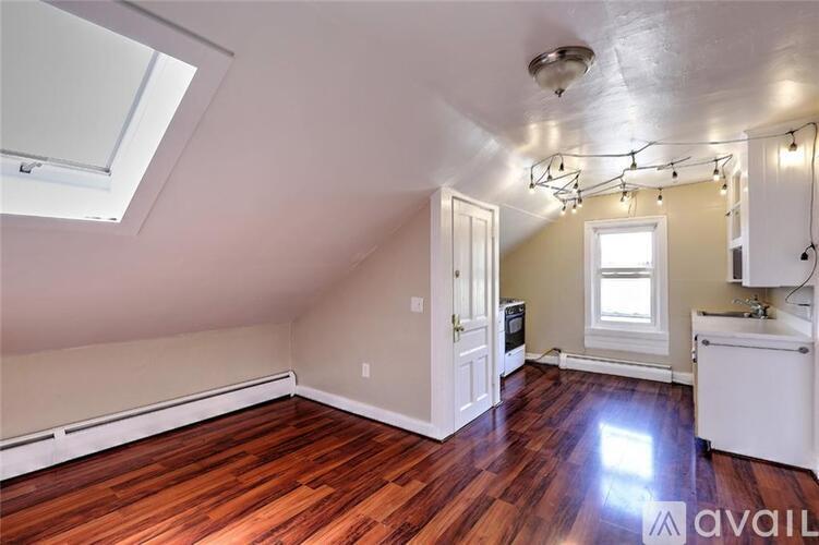 A room with a skylight and a kitchenette.