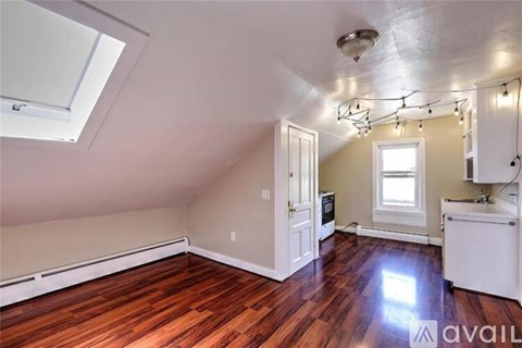 A room with a skylight and a kitchenette.