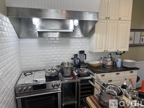 A kitchen with a stove top oven and a range hood.