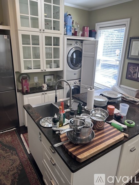 A kitchen with white cabinets and a wooden floor.