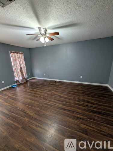 A room with wooden floors and a ceiling fan.