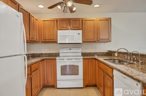 A kitchen with wooden cabinets and white appliances.