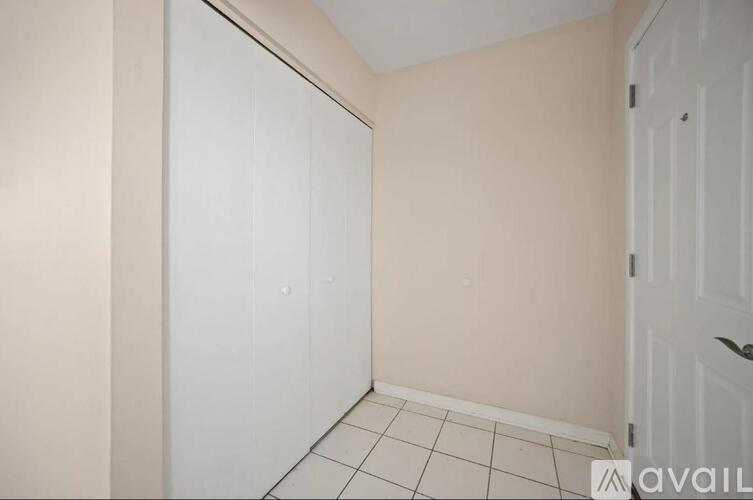 A room with a white door and a tiled floor.