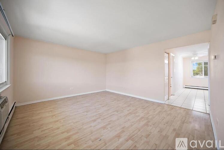 A room with wooden flooring and white walls.