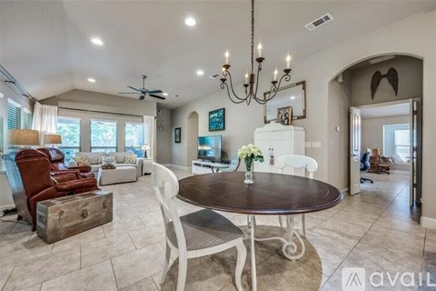 A living room with a brown table and white chairs.