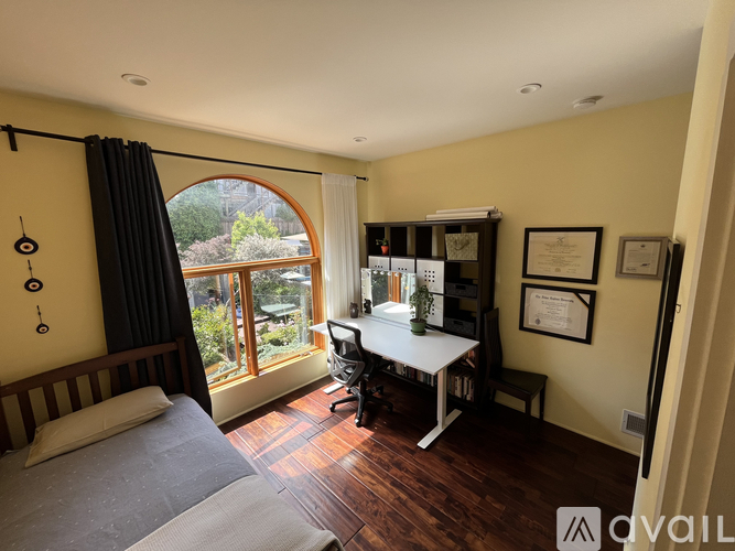 A bedroom with a large bed and a desk with a chair.