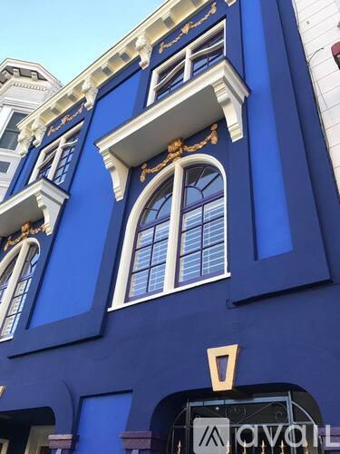 A blue building with a window and a sign that says "AVO".