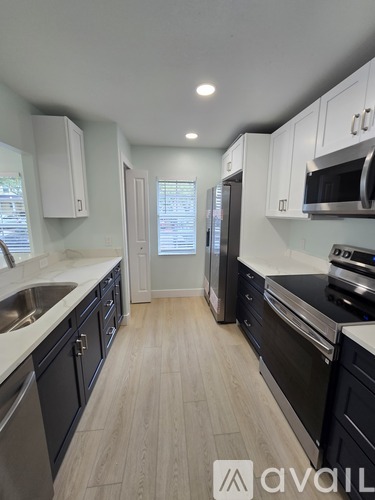 A kitchen with black cabinets and stainless steel appliances.