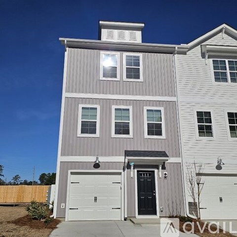 A two-story house with a garage and a driveway.