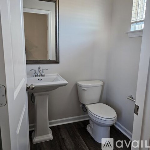 A white toilet and sink in a small bathroom.