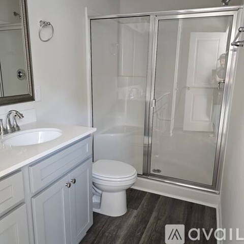 A bathroom with a toilet, sink, and shower.