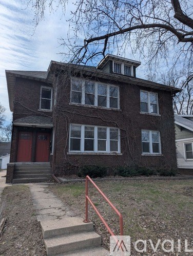 A house with a red door and a tree in front.