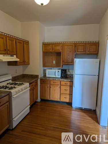 A kitchen with wooden cabinets and a white fridge.