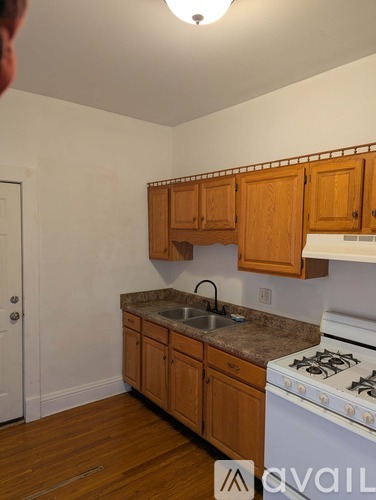 A kitchen with wooden cabinets and a white stove.