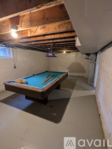 A pool table in a room with exposed ceiling beams.