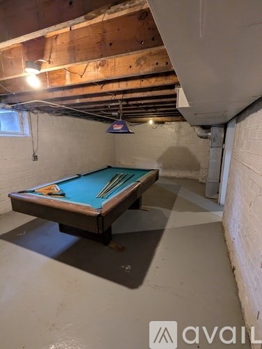 A pool table in a room with exposed ceiling beams.