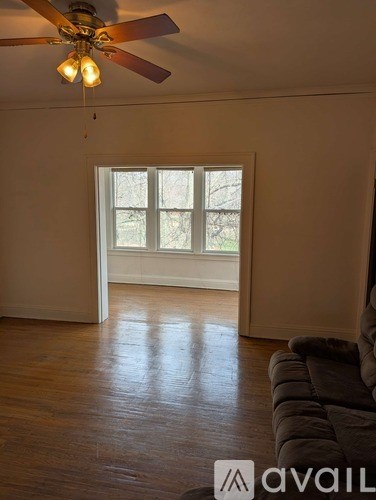 A living room with a couch and a ceiling fan.