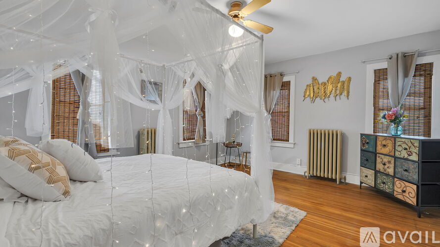 A bedroom with a canopy bed and a ceiling fan.