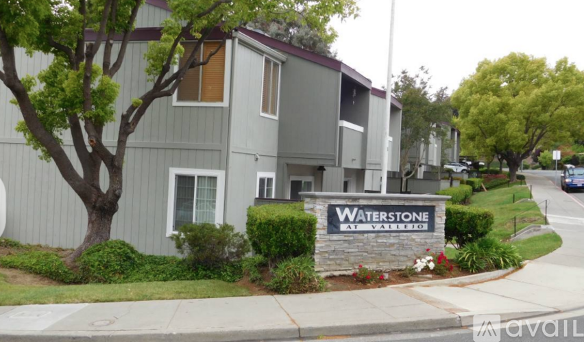A sign that says Waterstone at Vista is in front of some houses.