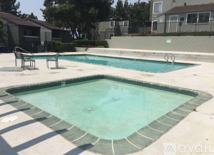 A small pool with a bench and a chair around it.
