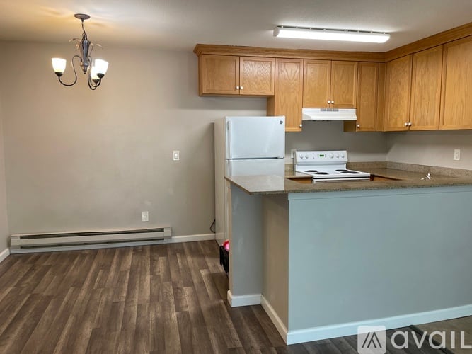 A kitchen with a white refrigerator and a stove top oven.