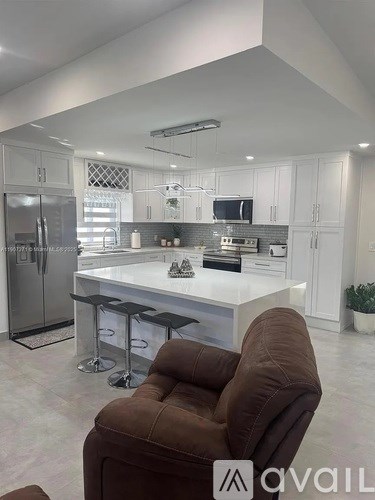 A brown recliner chair is in front of a kitchen island.