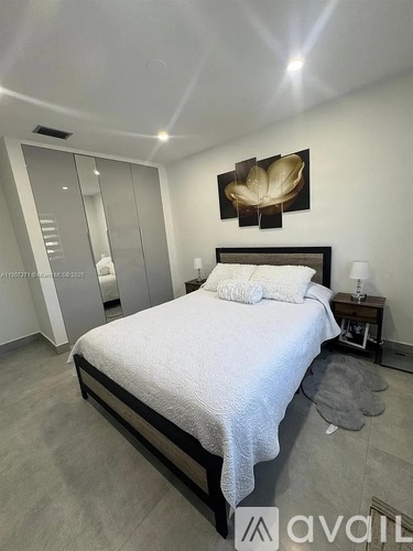 A bedroom with a large bed and a mirror on the wall.