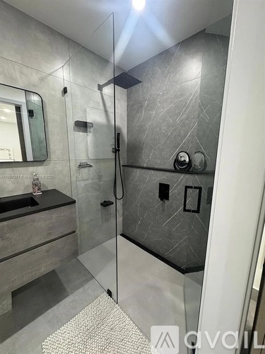 A bathroom with a walk in shower and a sink.
