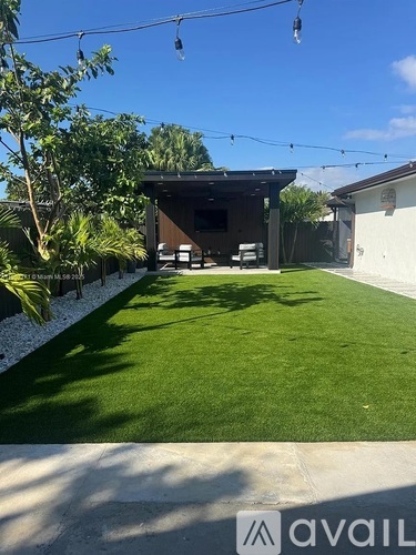 A backyard with a lawn and a building in the background.
