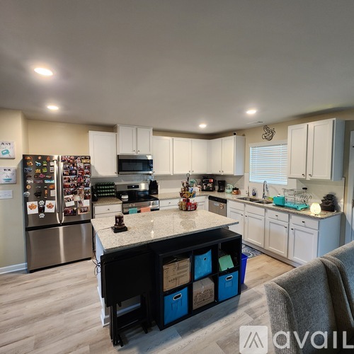 A kitchen with a refrigerator covered in magnets and a counter with a coffee maker.