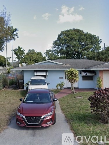 A red car is parked in front of a house.