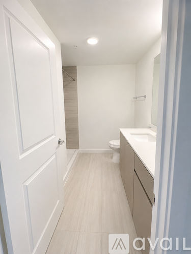 A spacious room with wooden flooring and white walls.