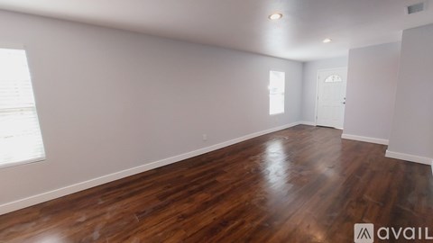 A room with wooden flooring and white walls.