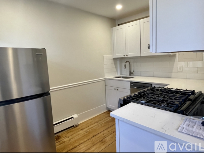 A kitchen with a stainless steel refrigerator and a white countertop.