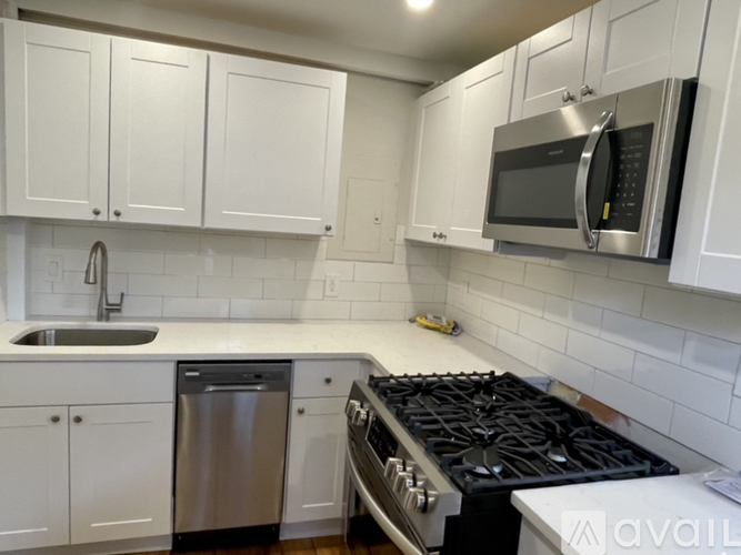 A kitchen with white cabinets and a black stove top.