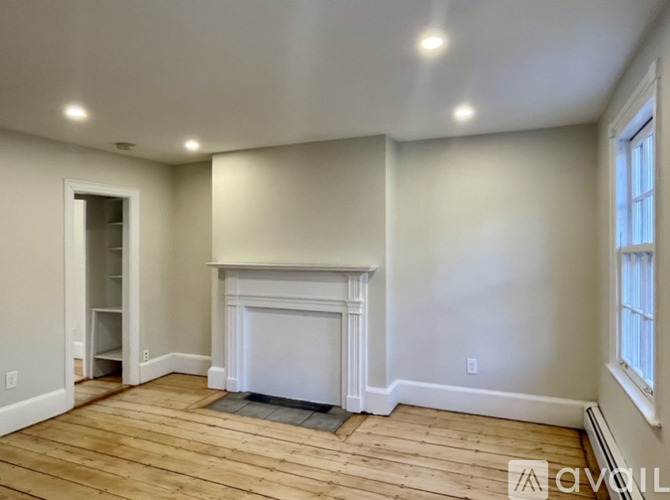 A living room with a fireplace and wood flooring.