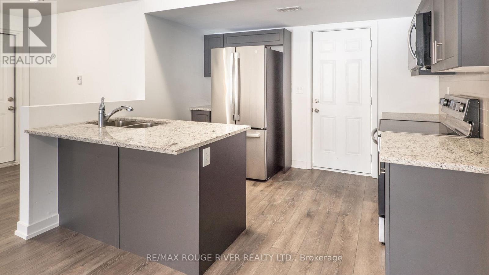 A kitchen with a granite countertop and a refrigerator.