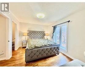 A bedroom with a large bed and a window with curtains.