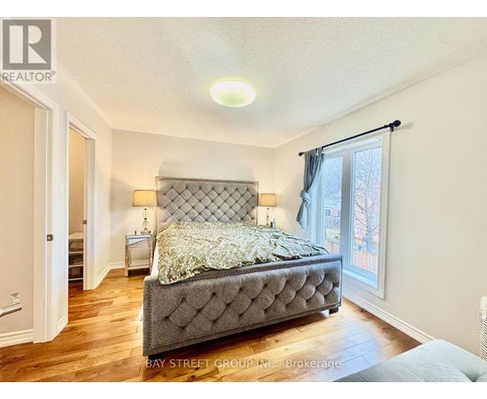A bedroom with a large bed and a window with curtains.