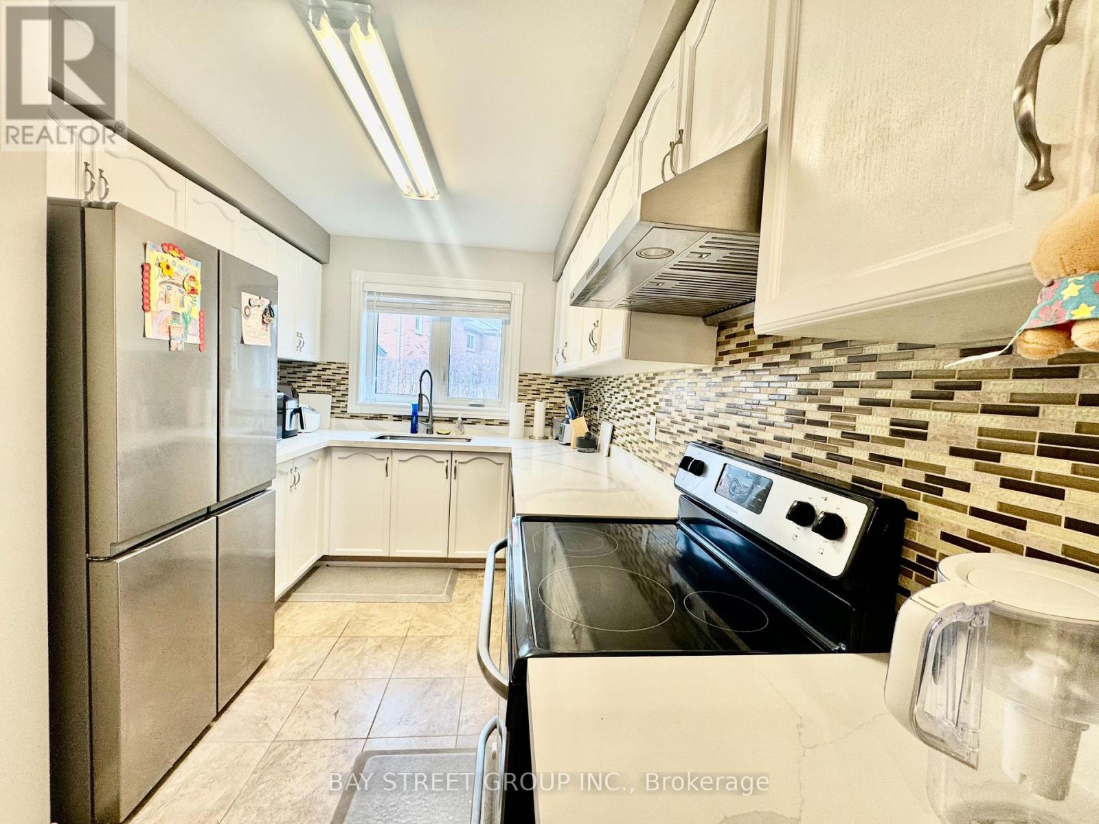 A kitchen with a stove top oven and a refrigerator.