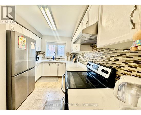 A kitchen with a stove top oven and a refrigerator.