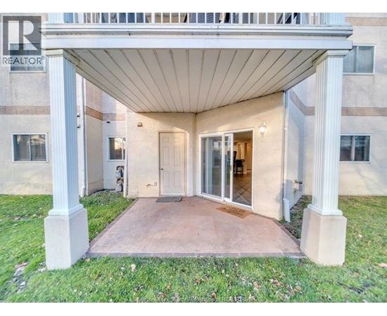 A building with a covered entrance and a Realtor sign.