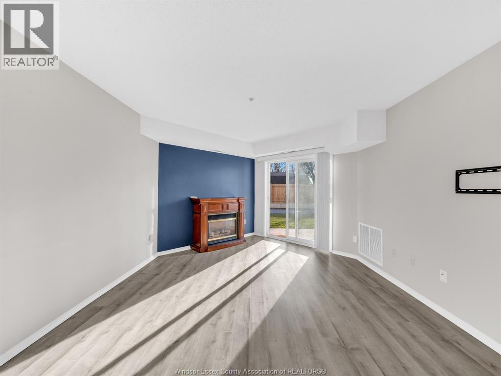 A spacious room with a fireplace and wooden flooring.