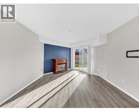 A spacious room with a fireplace and wooden flooring.