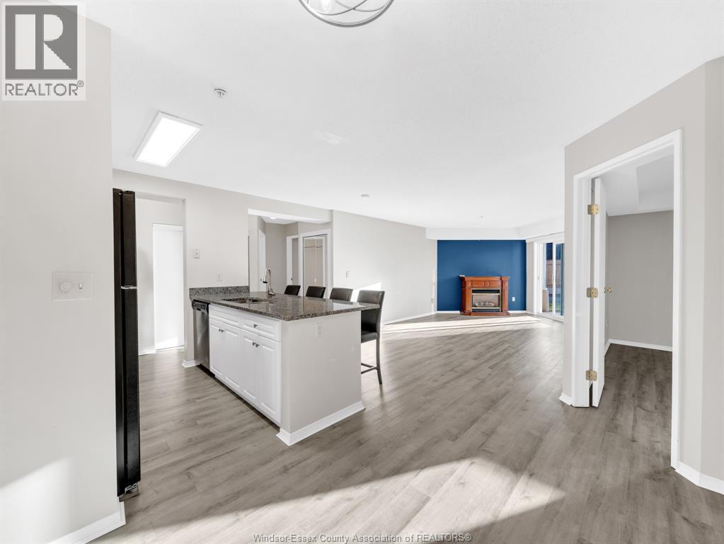 A modern kitchen with white cabinets and a wooden floor.