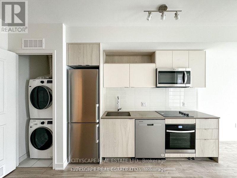 A kitchen with a refrigerator, oven, and microwave.