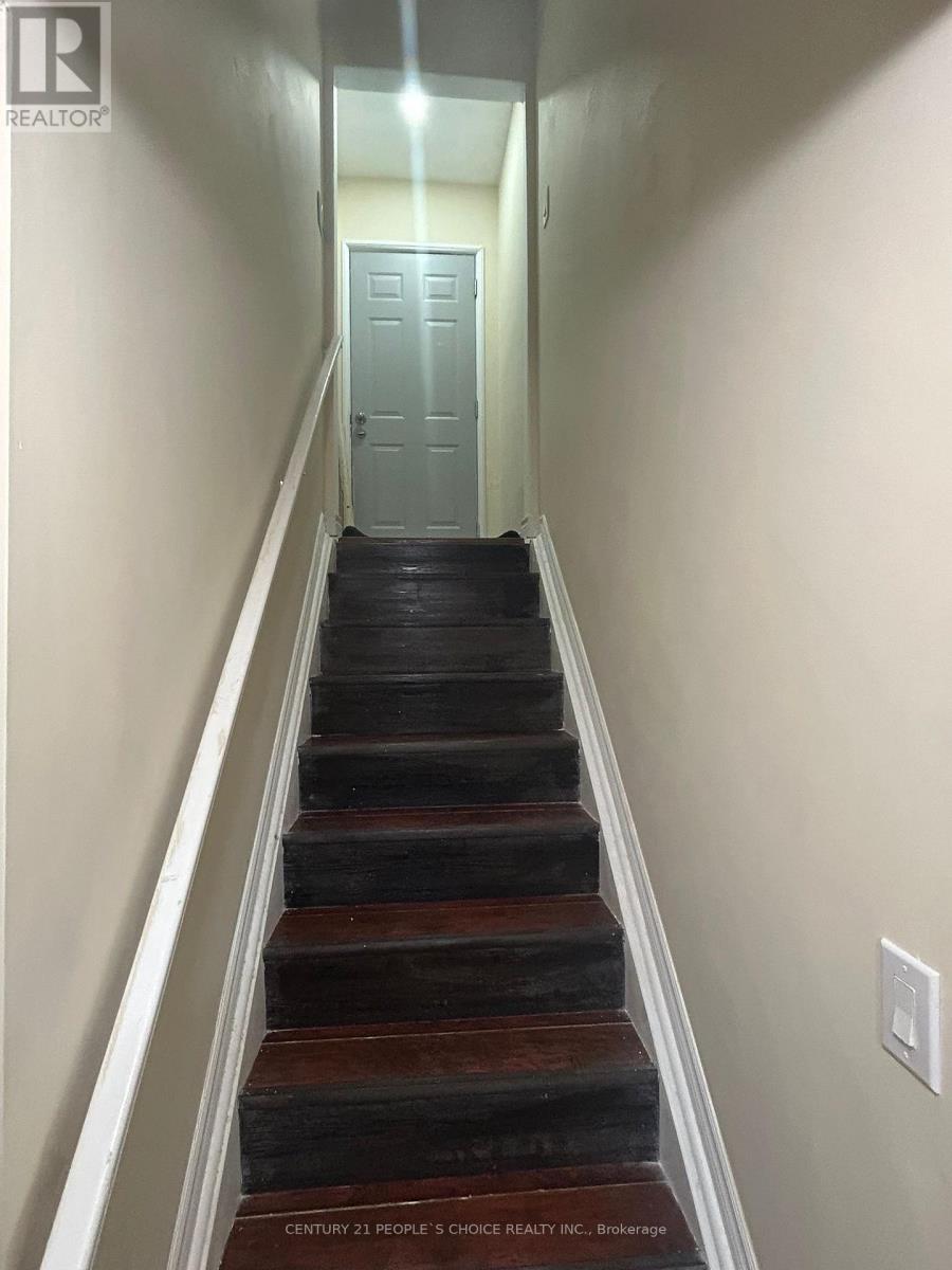 A staircase with a light switch on the wall.