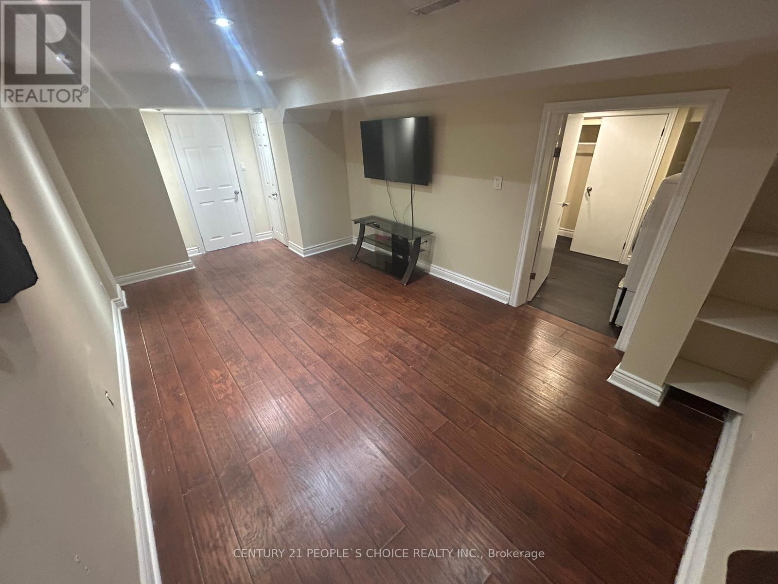 A living room with wood flooring and a flat screen TV.